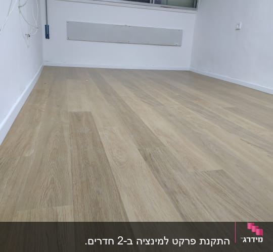 רצפת פרקט עץ בהירה בחדר ריק עם קירות לבנים